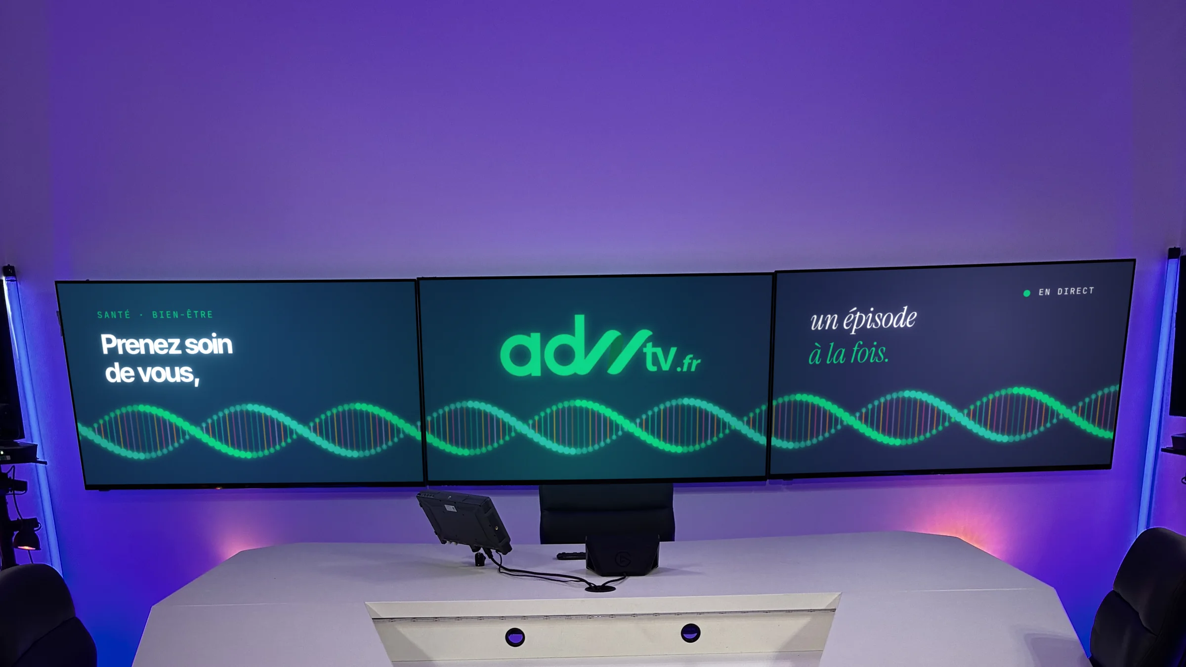Configuration signature en lumière violette, écrans habillés aux couleurs d’ADNtv avec une double hélice d’ADN animée